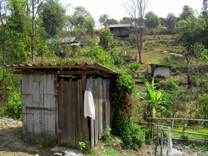 A bathroom with Karen homes in the background, A Karen toilet is small (not beautiful) at a Aunt's house.